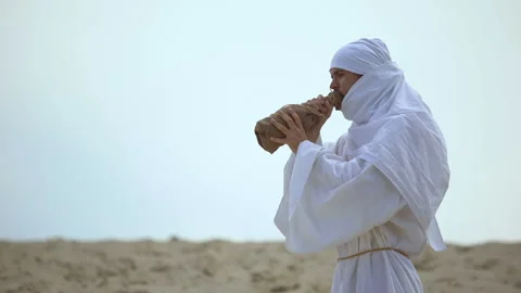 Thirsty arab pilgrim drinking water from bottle in desert, drought problems Stock Footage 112652091