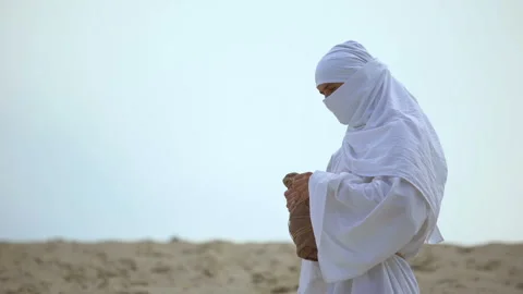 Thirsty arab pilgrim drinking water from bottle in desert, drought problems Stock Footage 112656401