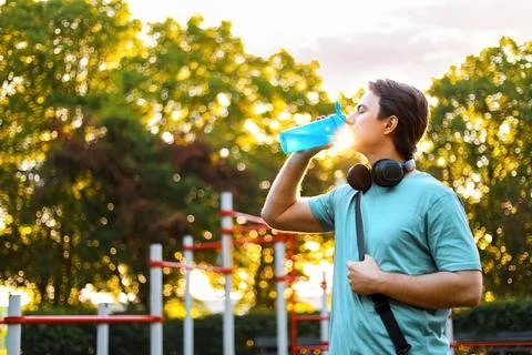 A thirsty man drinking water for hydration after an outdoor fitness workout.. Stockfoto's
