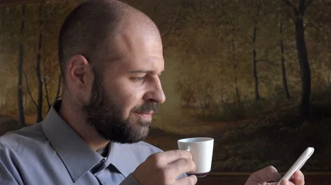 Thirty years  peaceful man does breakfast with coffee and writing sms Stock Footage 68576714