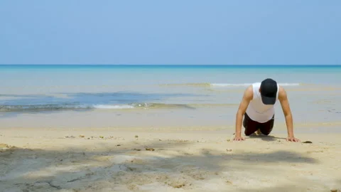 Thletic man workout by  push up at the sandy beach Stock Footage 133342104