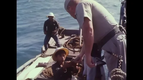 AN THOI - 1965 - Crewmembers search the junk of an older Vietnamese man near An Stock Footage 341862706