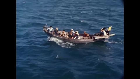 AN THOI - 1965 - A junk carrying several Vietnamese locals approaches USCGC Stock Footage 341862702