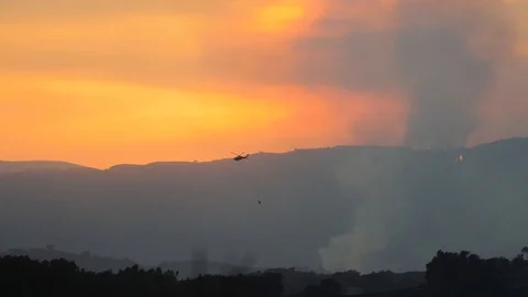 The Thomas fire burns at sunset in the hills above Ojai, California with water Stockbeeldmateriaal 114571332