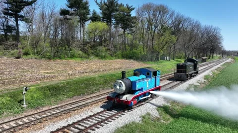 Thomas the Tank Engine runs on a railway track, blowing steam out its side Видео 331700577
