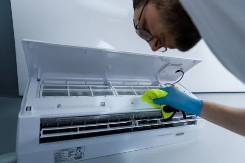 Thorough Cleaning Process of an Air Conditioner Unit by a Focused Individual Stock Photos