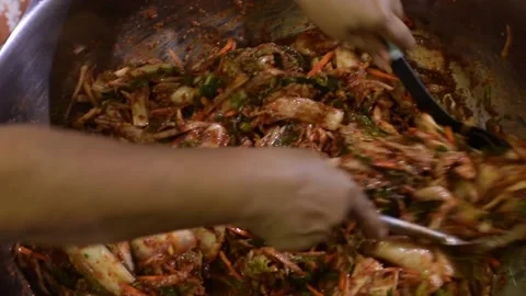 Thorough stir mixing of chili paste in napa cabbage on mixing basin in making Stock Footage 172427997