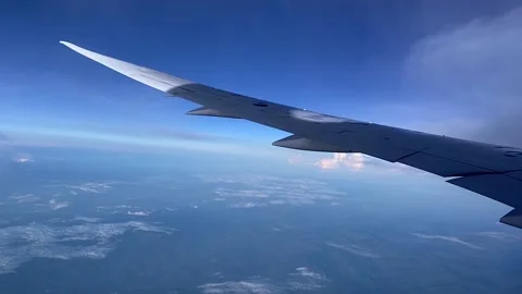 Though the window portal view over the wing of Aircraft air plane flying high al Stock Footage 230119420