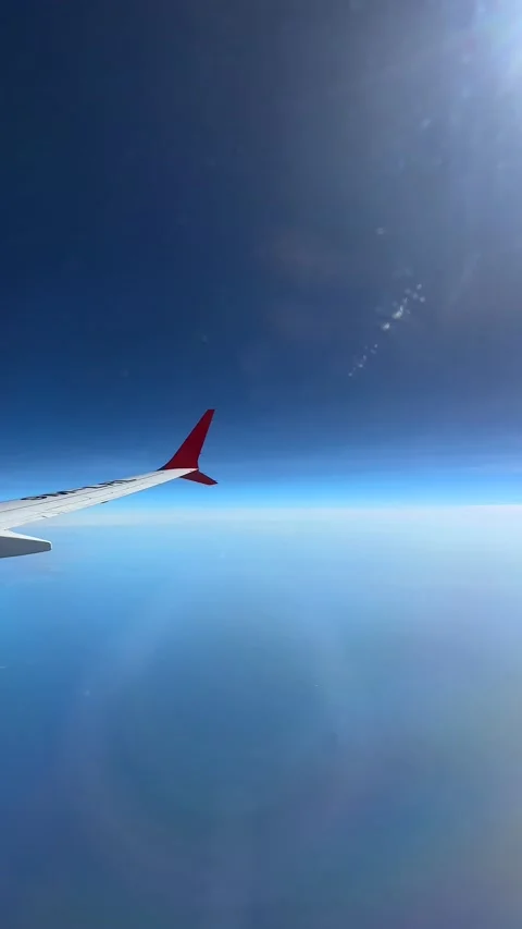 Though the window portal view over the wing of Aircraft air plane flying high al Stock Footage 230119434