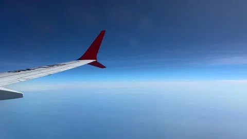 Though the window portal view over the wing of Aircraft air plane flying high al Stock Footage 230119436