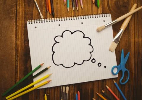 Thought bubble drawn on notebook placed with coloring tools Stock Photos