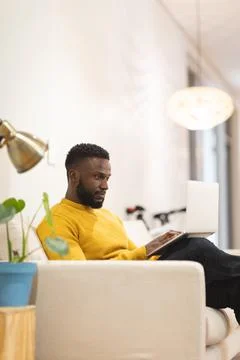 Thoughtful african american male business creative sitting on sofa in workplace Stock Photos