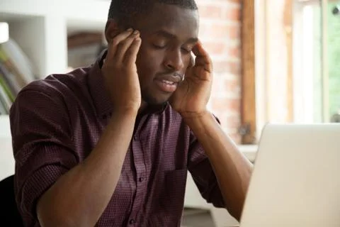 Thoughtful African American solving problem working at laptop Foto stock