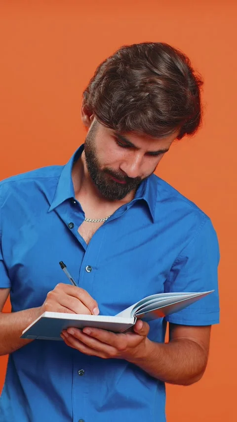 Thoughtful arabian man making notes, writing down thoughts with pen into notepad Stock Footage 347617246