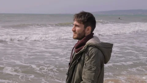 Thoughtful attractive young man walking alone on the beach in winter day Stock-Footage 105026465