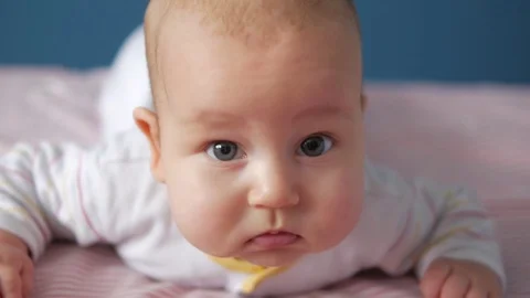 Thoughtful baby looking attentevly to the camera. Close up portrait Stock Footage