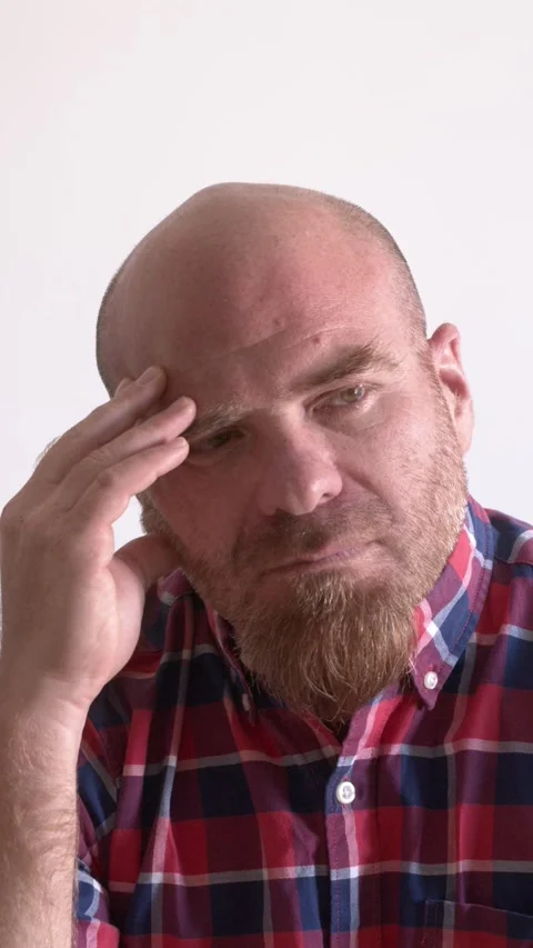 Thoughtful Bald Man with Red Goatee Touches Head in Contemplation Stock Footage 299938877