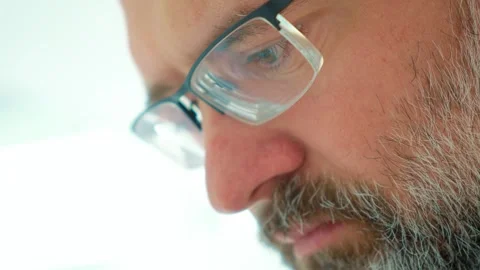Thoughtful bearded man touching his beard while looking down, appearing worried Stock Footage 345125776