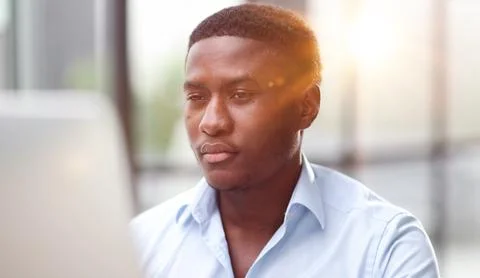 Thoughtful black man in eyeglasses stack with hard task, looking at computer Foto stock