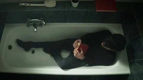 Thoughtful boy in the bathtub with clothes Stock Footage 169238139