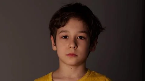 Thoughtful boy looking at camera. Young sad thinking curiosity kid looking at Foto stock