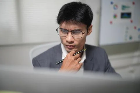 Thoughtful Businessman Analyzing Computer Screen in Office Stock Photos
