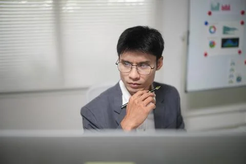Thoughtful Businessman Analyzing Data in Office Stock Photos