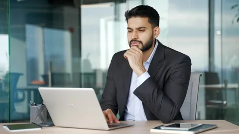 Thoughtful businessman thinking about problem solving while working on laptop  Stock Footage 334862058
