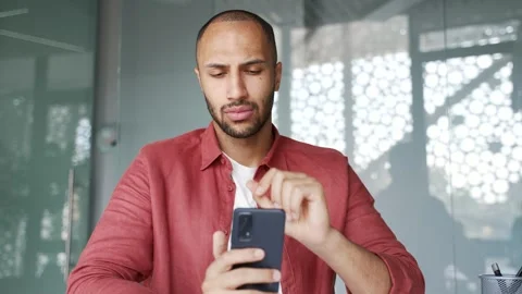 Thoughtful businessman is using browsing mobile phone sitting at workplace  Stock Footage 311622501