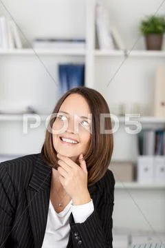 Thoughtful businesswoman with hand on chin looking away Stock Photos