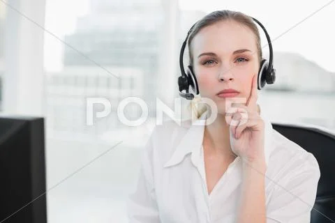 Thoughtful call centre agent looking at camera Stock Photos