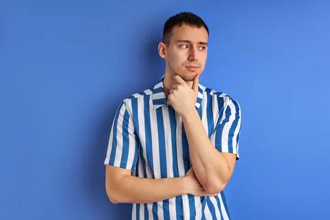 Thoughtful caucasian guy thinking try solve problem pose isolated on blue studio Stock Photos