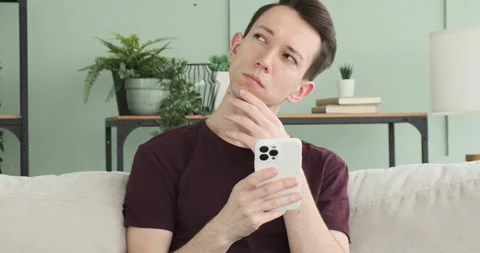 Thoughtful Caucasian Man Using Phone on the Sofa Stock-Footage 248532415