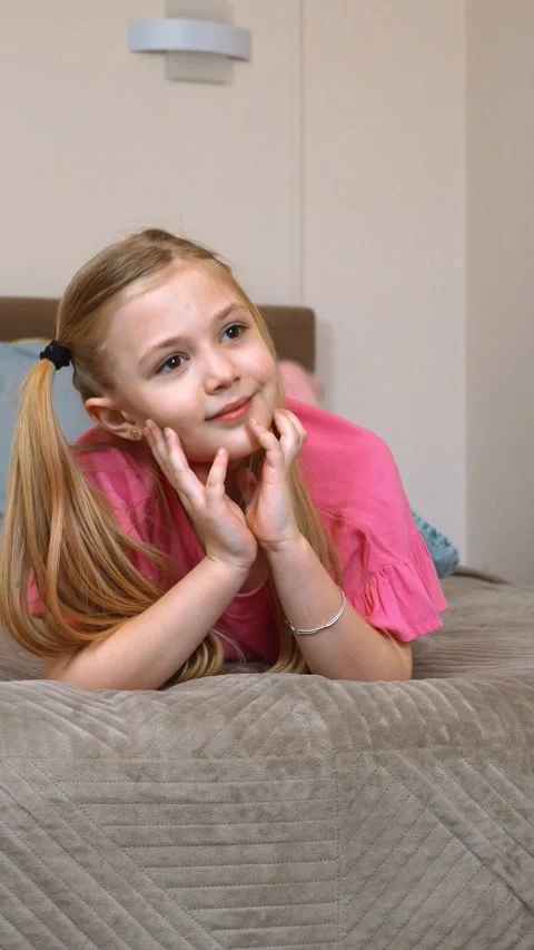 Thoughtful child lying on bed expressing different emotions 库存影片 315880497