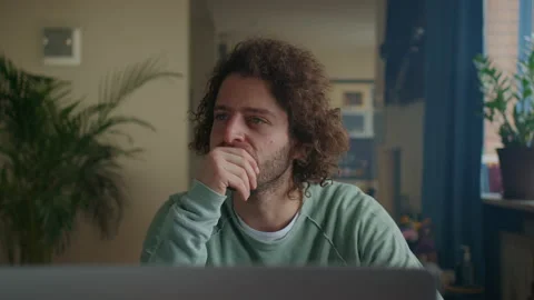 Thoughtful concerned curly men working on laptop computer looking away thinking Stock Footage 192078738