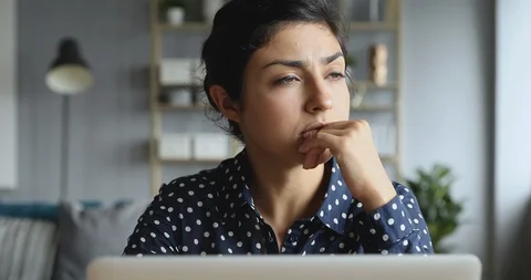 Thoughtful concerned indian woman working on computer thinking solving problem Stock Footage