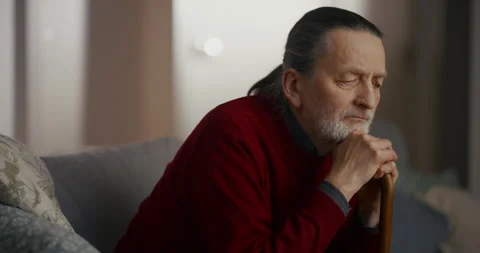 Thoughtful elderly man resting by a window in a quiet home Видео 336278280