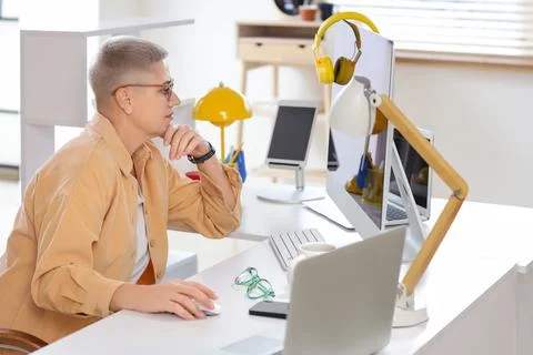 Thoughtful female programmer working at desk in office Stock Photos