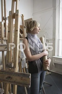 Thoughtful Female Student Amid Easels Stock Photos
