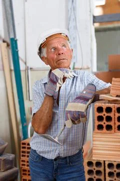 Thoughtful foreman near stack of bricks 写真素材