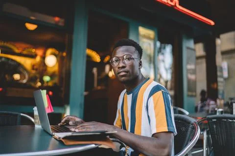 Thoughtful freelancer using laptop in cafe Stock Photos