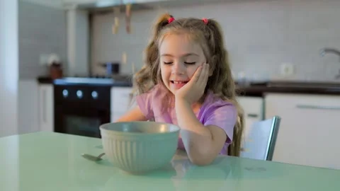 Thoughtful Girl Sitting At Table With Breakfast Cereal Bowl At Home Morning Stock Footage 339216292