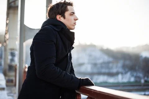 Thoughtful guy standing on the bridge looking into the distance Stock Photos