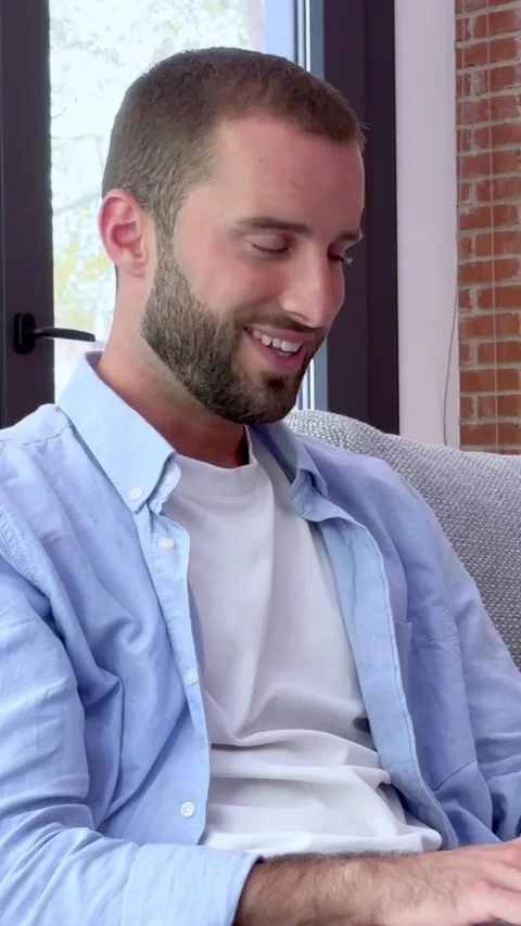 Thoughtful handsome man with a beard sitting on a couch, thinking Stock Footage 345117388