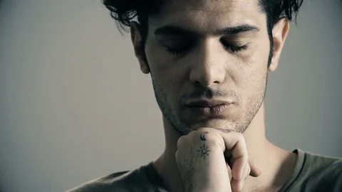 Thoughtful handsome man opens his eyes and stares camera Stock Footage 77553154