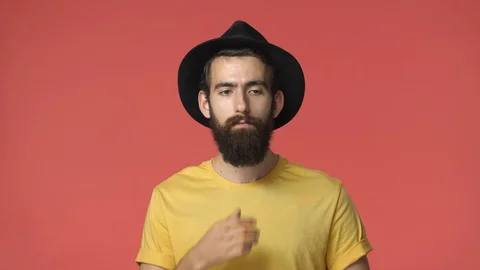 Thoughtful handsome middle-eastern bearded guy in black hat and yellow t-shirt Stock-Footage 115781889