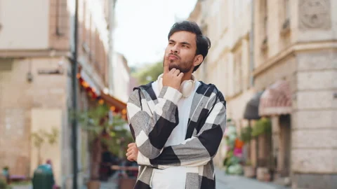 Thoughtful inspired Indian young man make gesture raises finger came up with Stock Footage 321183272