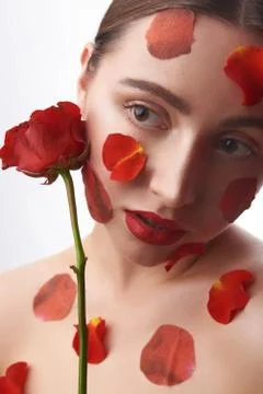 Thoughtful lady looking away while posing with red rose Stock-Fotos