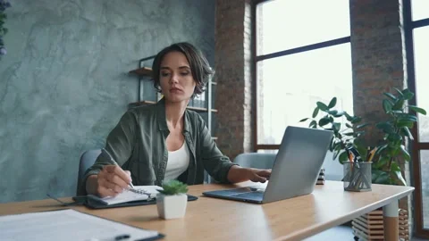 Thoughtful lady sit table use netbook communicate partners in workspace Stock Footage 167680848