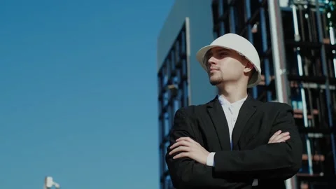 Thoughtful male builder is thinking about something with his arms crossed at the Vídeos de archivo 249263158
